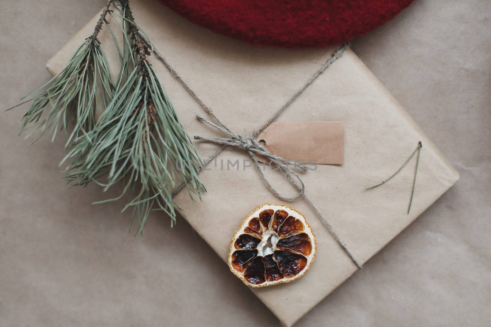 Christmas composition. Gift, fir tree branches, balls on craft paper background. Christmas, winter, new year concept. Flat lay, top view, copy space.