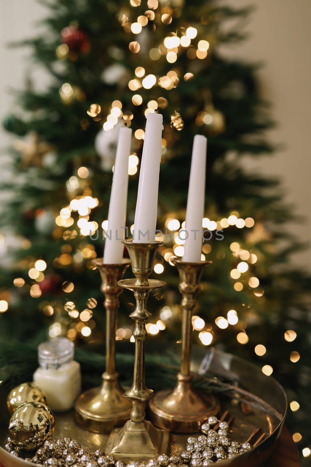 Christmas candles and ornaments over dark background with lights by paralisart