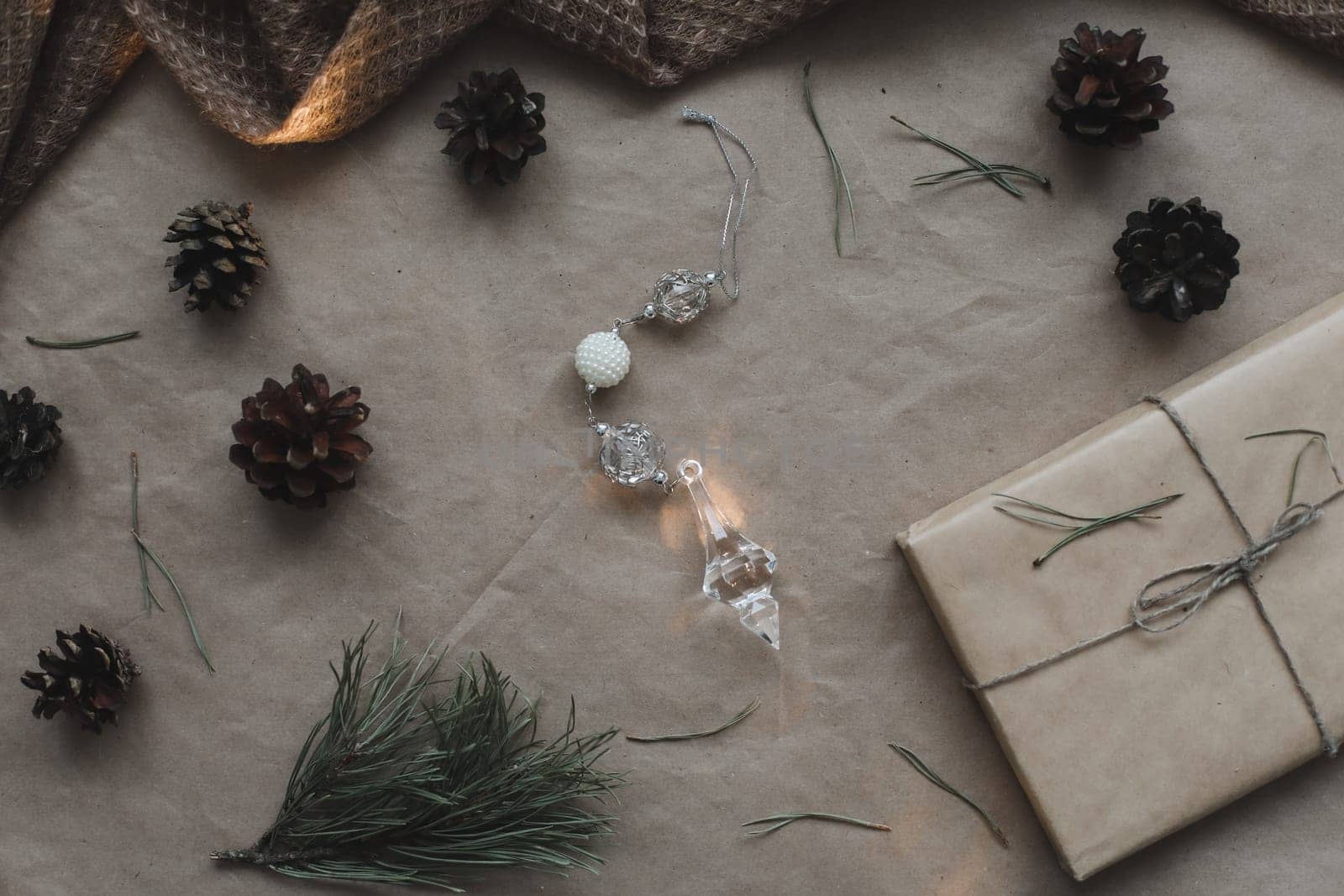 Christmas composition. Gift, fir tree branches, balls on craft paper background. Christmas, winter, new year concept. Flat lay, top view, copy space.