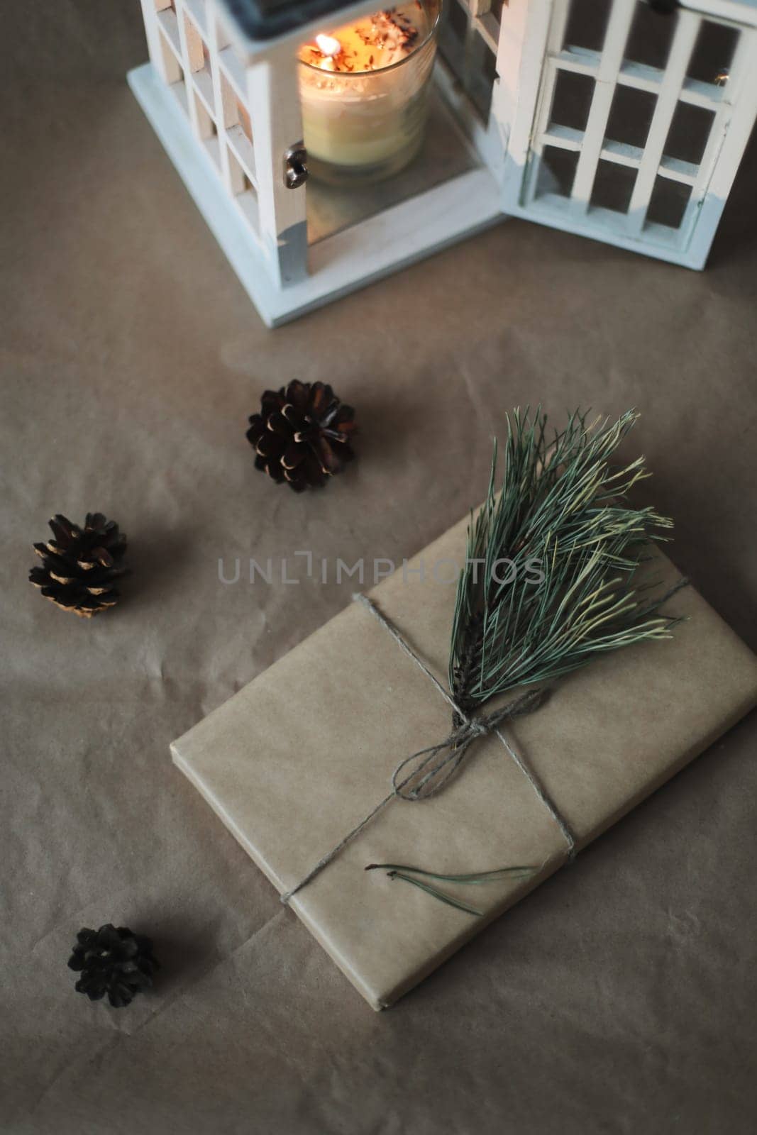 Christmas composition. Gift, fir tree branches, balls on craft paper background. Christmas, winter, new year concept. Flat lay, top view, copy space.