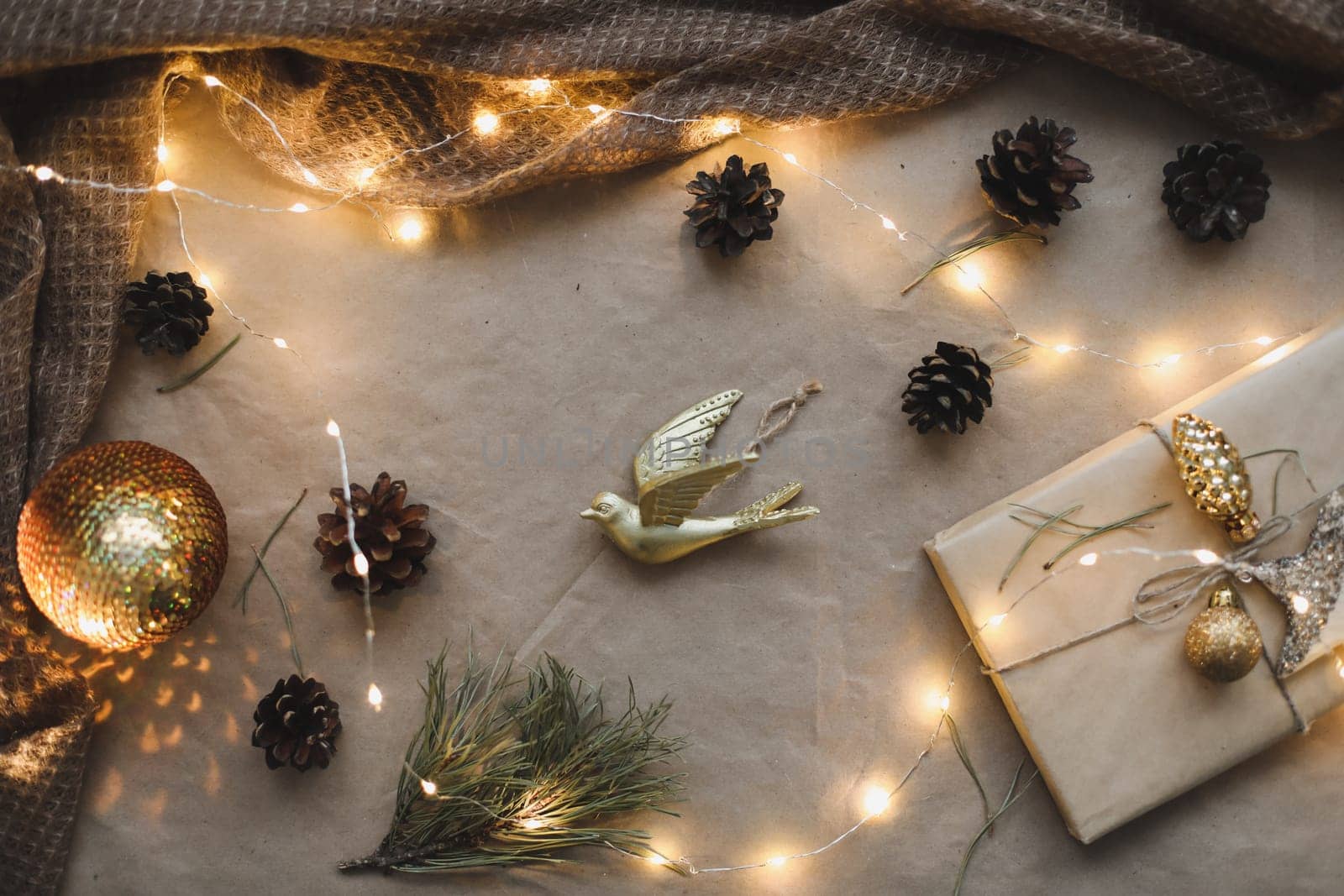 Christmas composition. Gift, fir tree branches, balls on craft paper background. Christmas, winter, new year concept. Flat lay, top view, copy space.