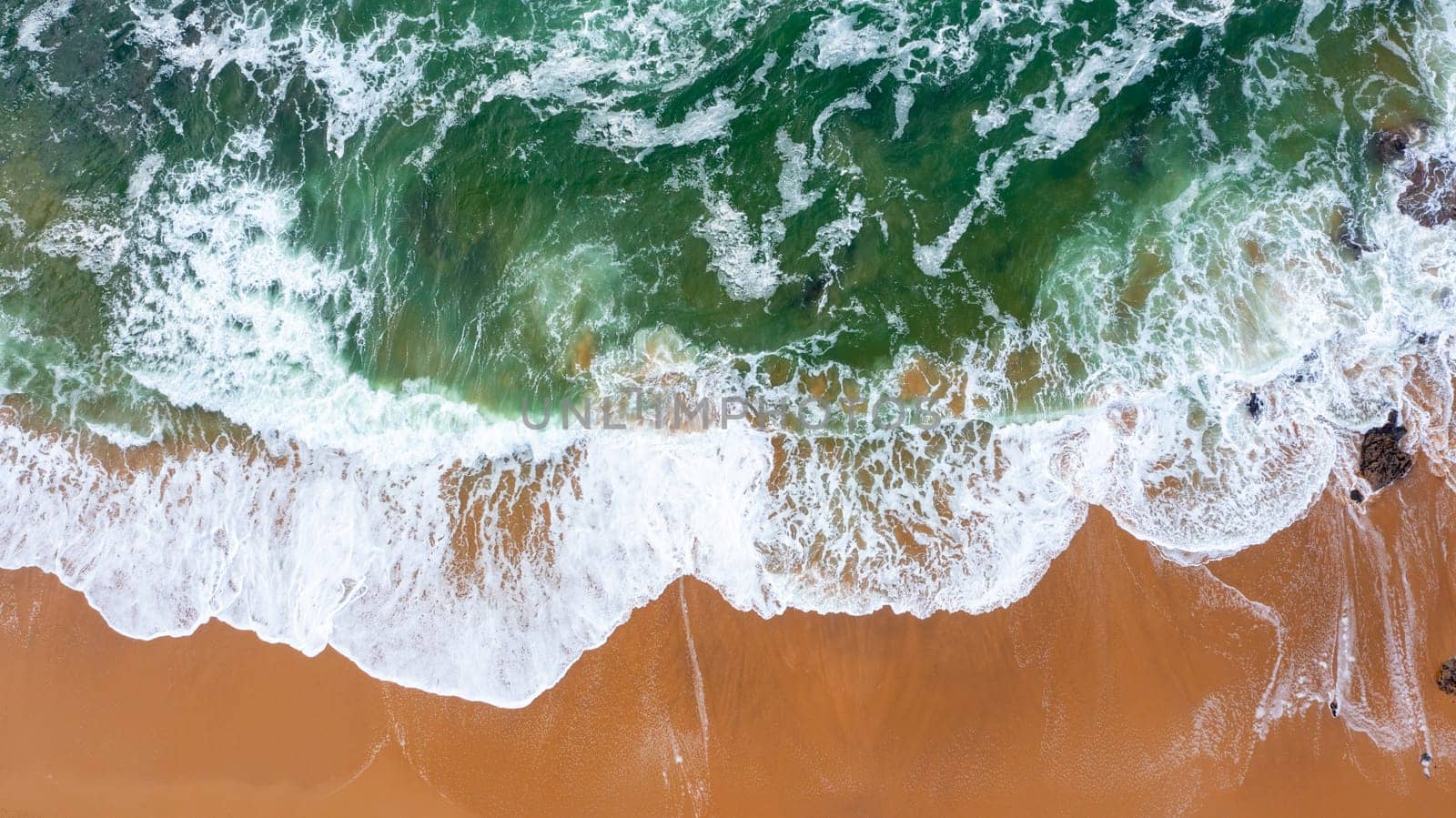 Wave on the beach with sand and turquoise waves aerial view
