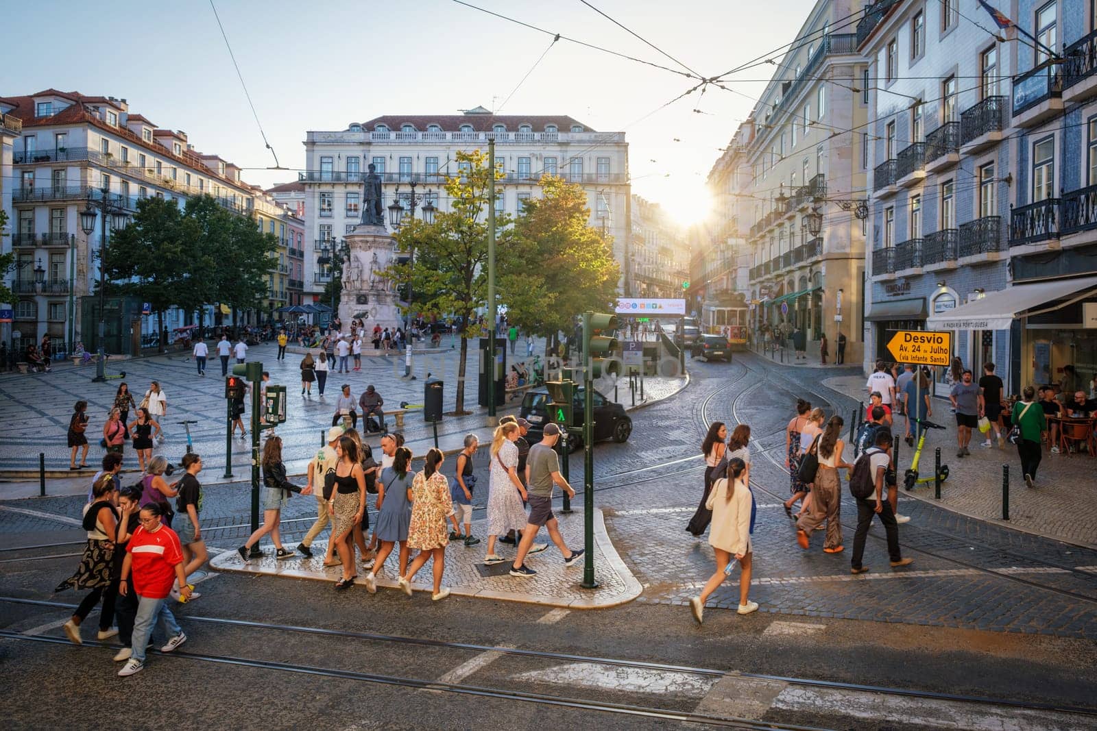 People crossing the road at the crowded Luis De Camoes square Praca Luis de Camoes in Lisbon by dimol