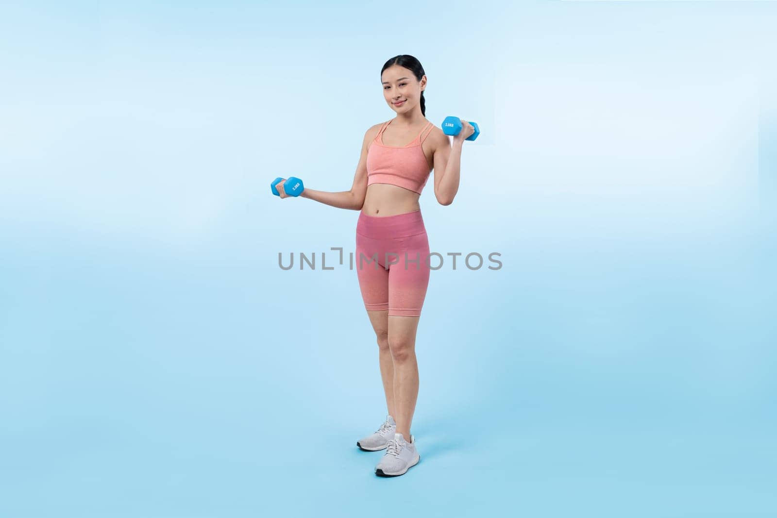 Vigorous energetic woman doing yoga with dumbbell weight exercise. by biancoblue