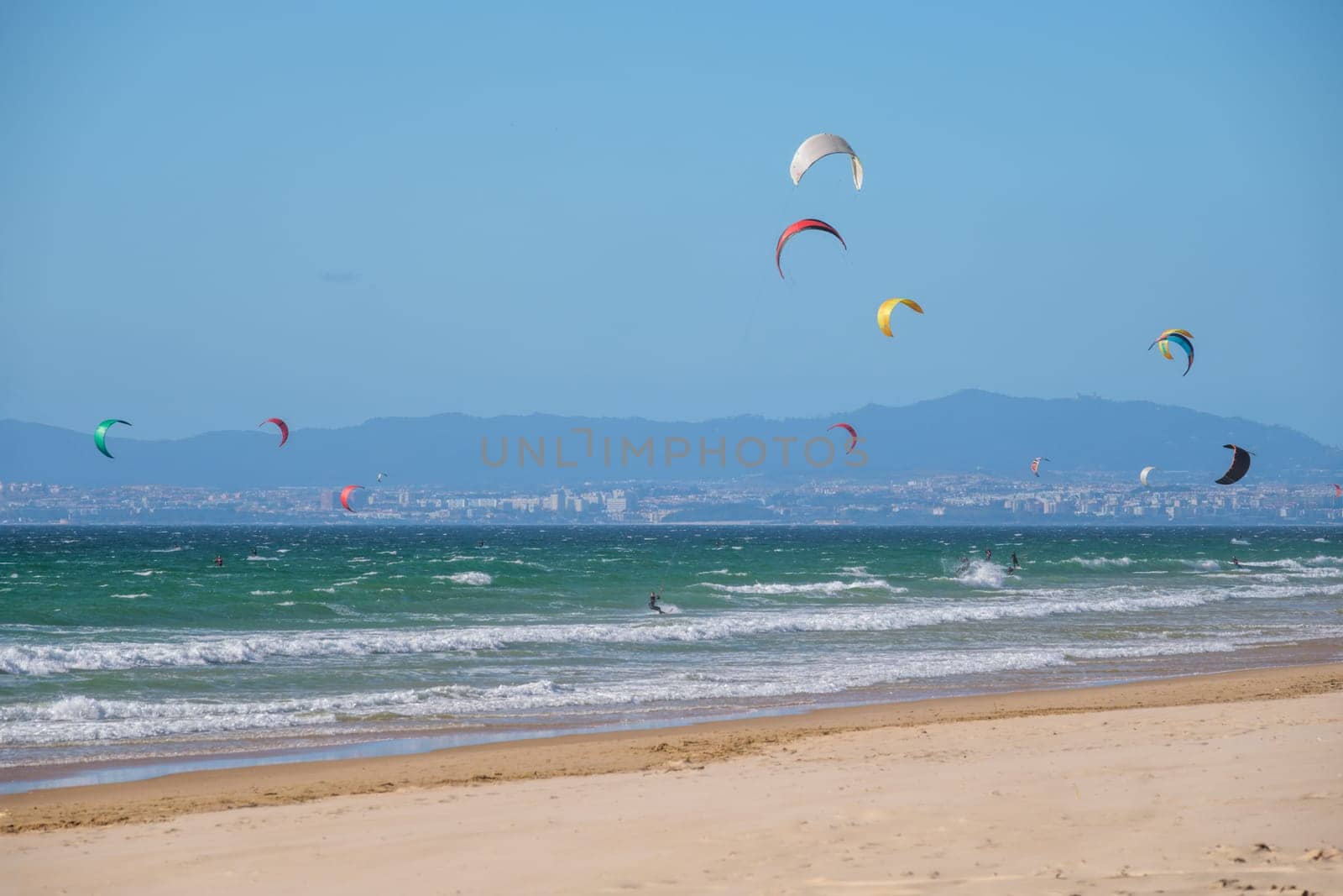 Kiteboarding kitesurfing kiteboarder kitesurfer kites on the Atlantic ocean beach at Fonte da Telha beach, Costa da Caparica, Portugal