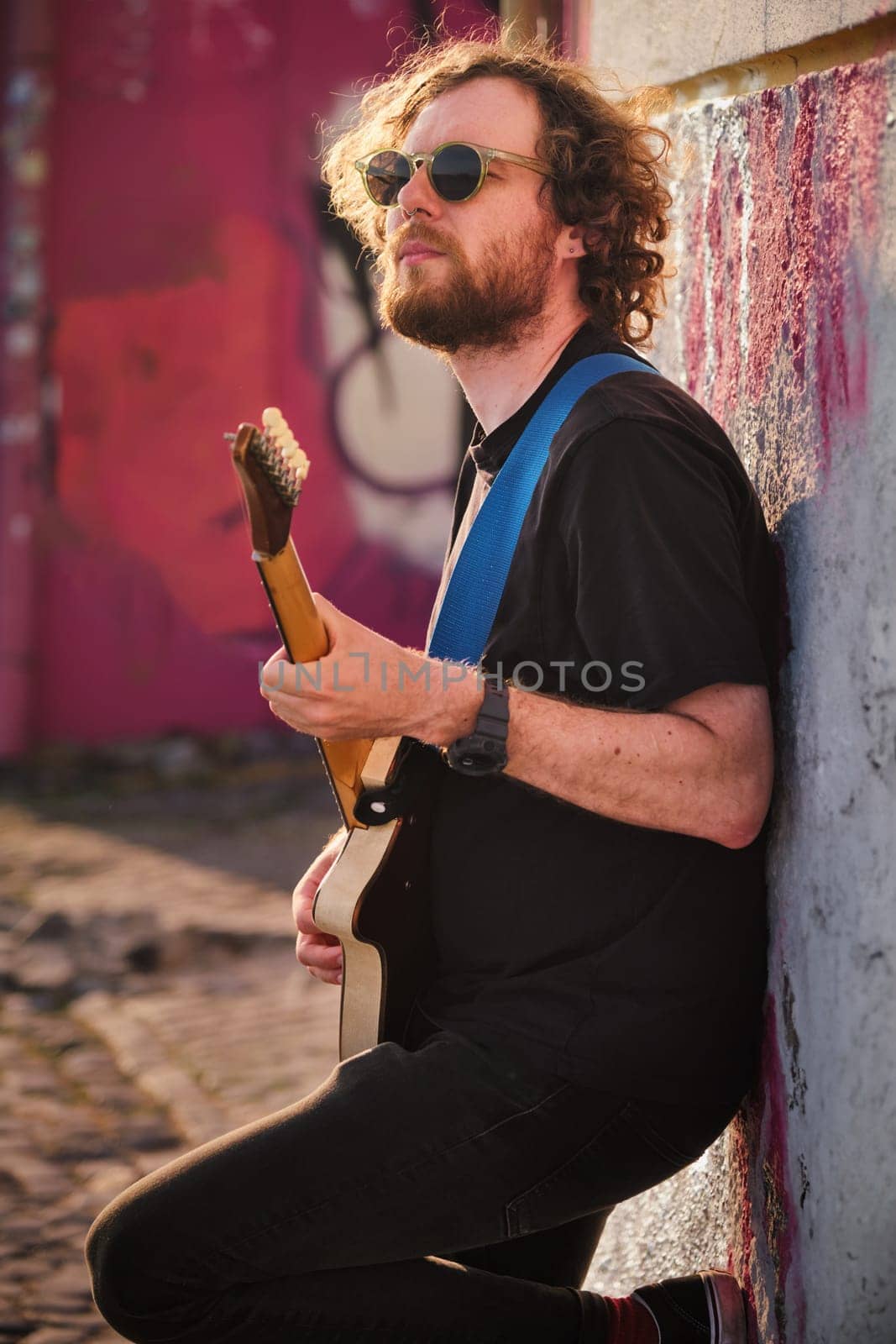 Street musician playing electric guitar in the street by dimol