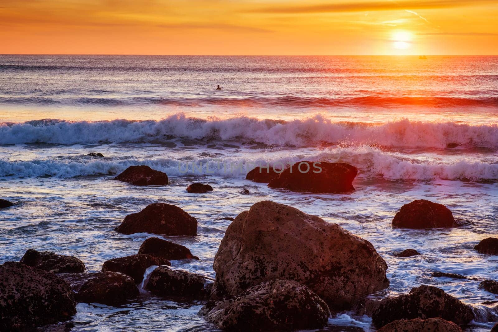 Atlantic ocean sunset with waves and rocks at Costa da Caparica, Portugal by dimol