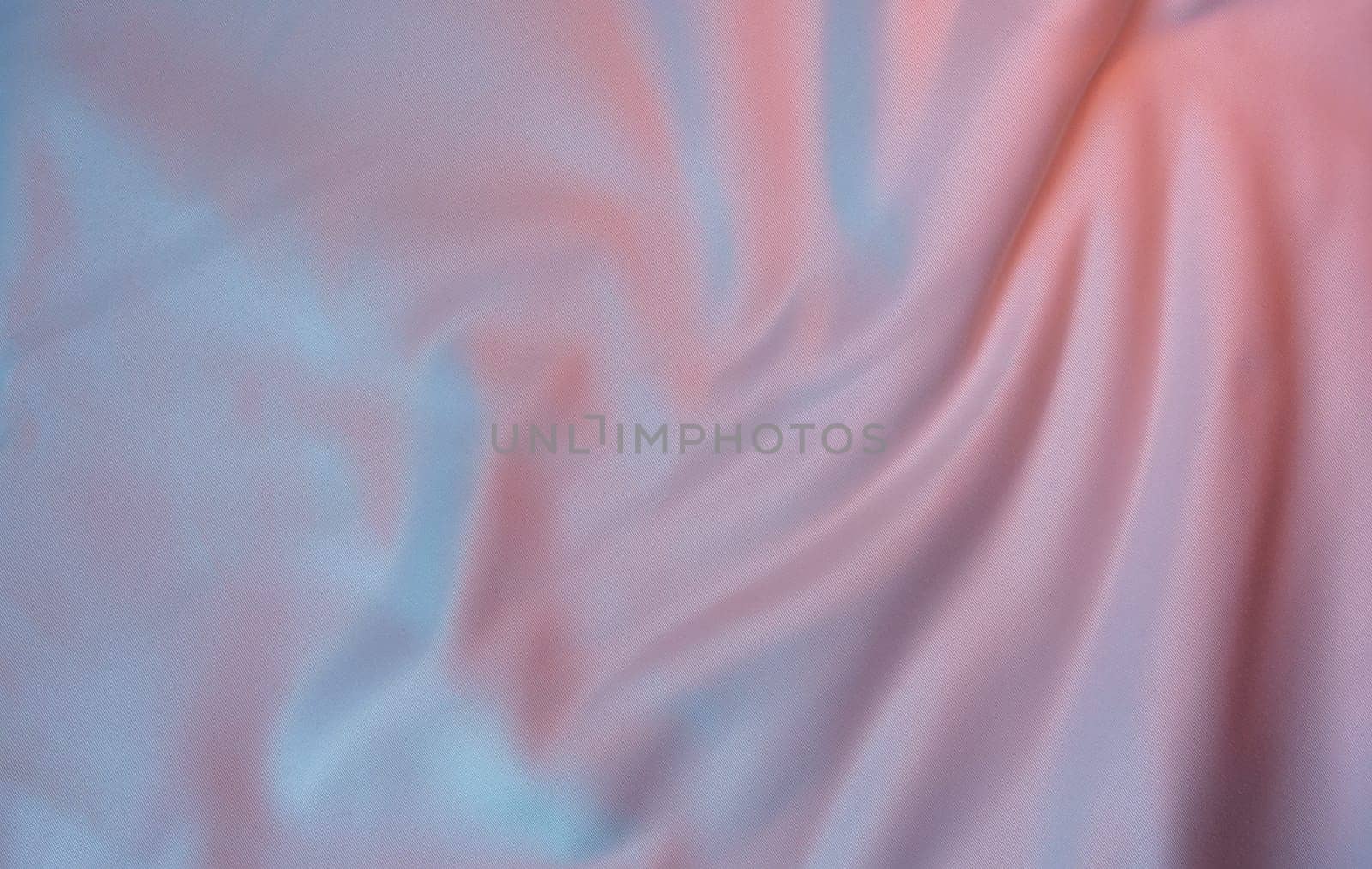 Light fabric with a pastel pink and blue gradient, featuring soft folds and a smooth texture. Ideal for backgrounds, templates, and design projects with copy space