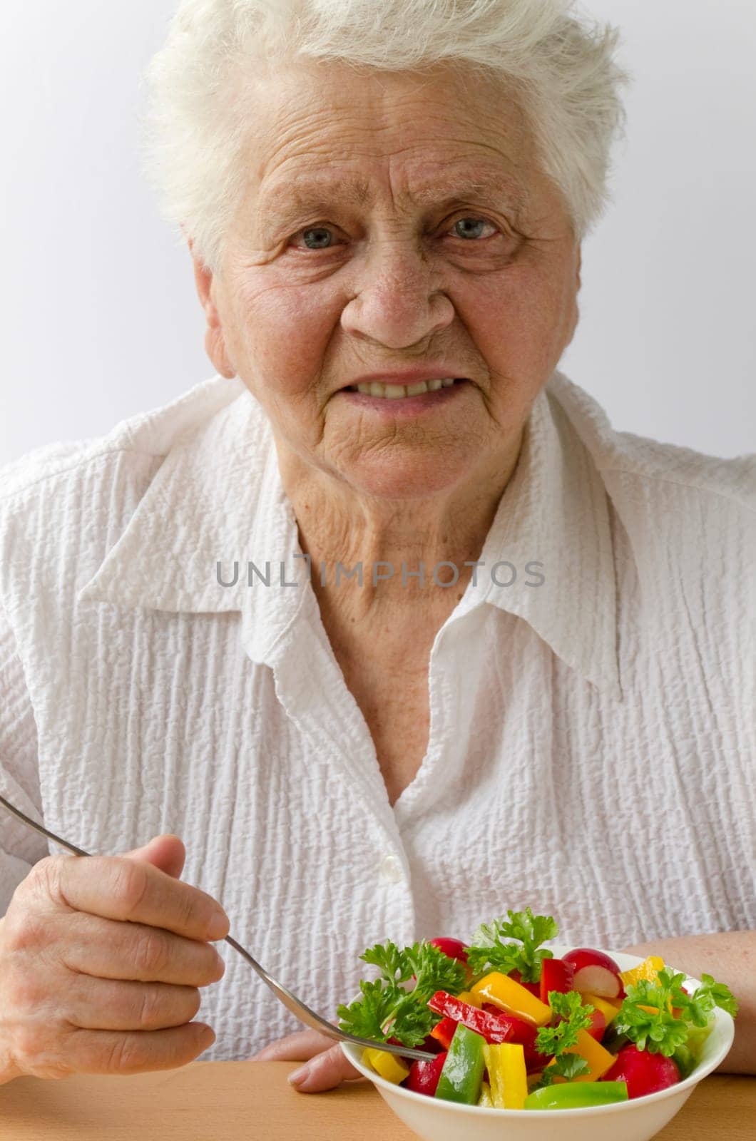Senior woman eating vegetable salad