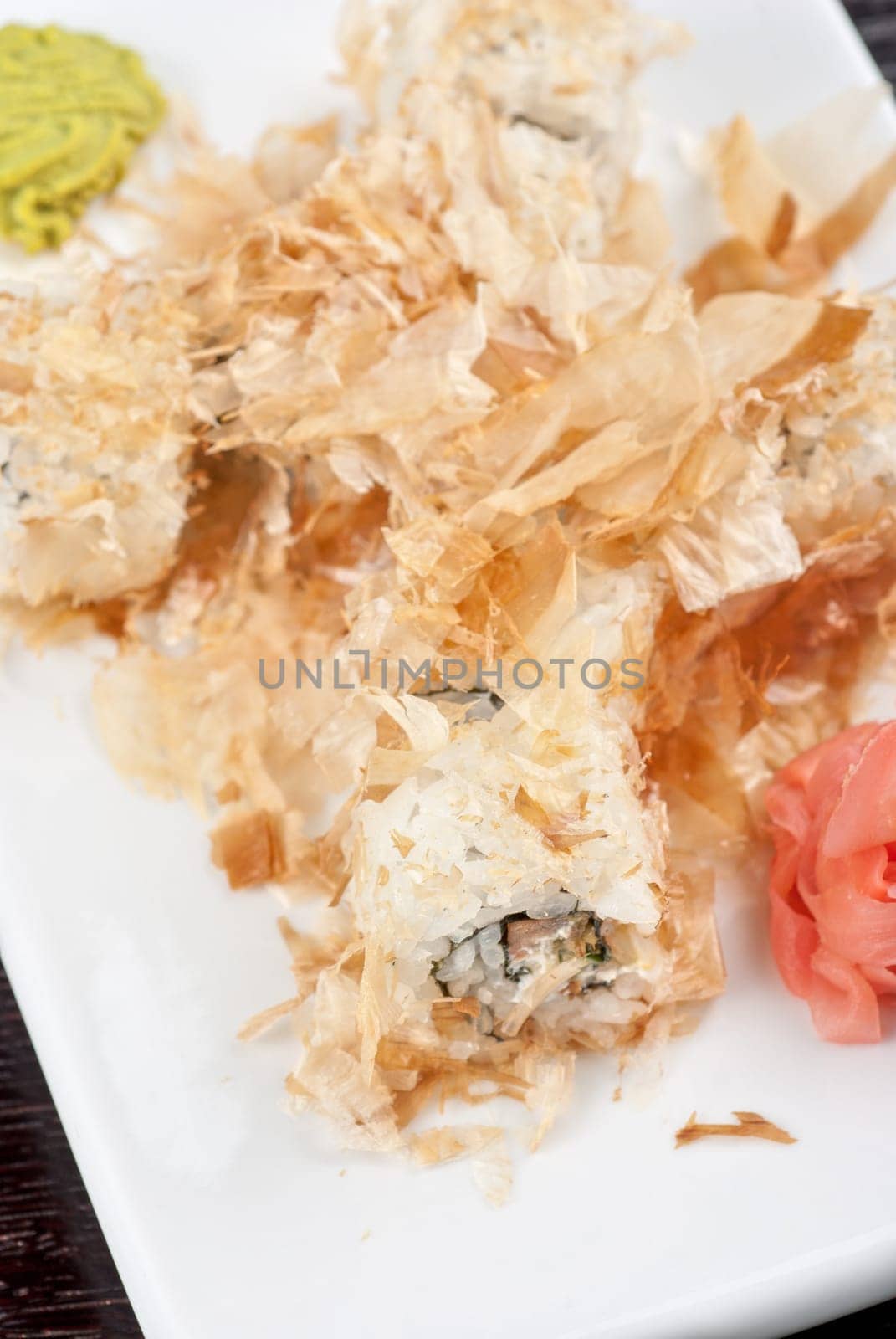 Sushi rolls of rice, nori, cream cheese, avocado, smoked salmon,cucumber and cuts of tuna