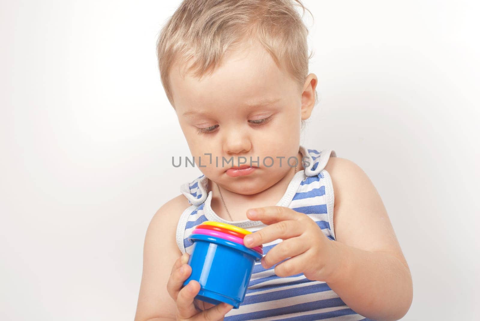 Small baby boy with a toy pyramid isolated on white