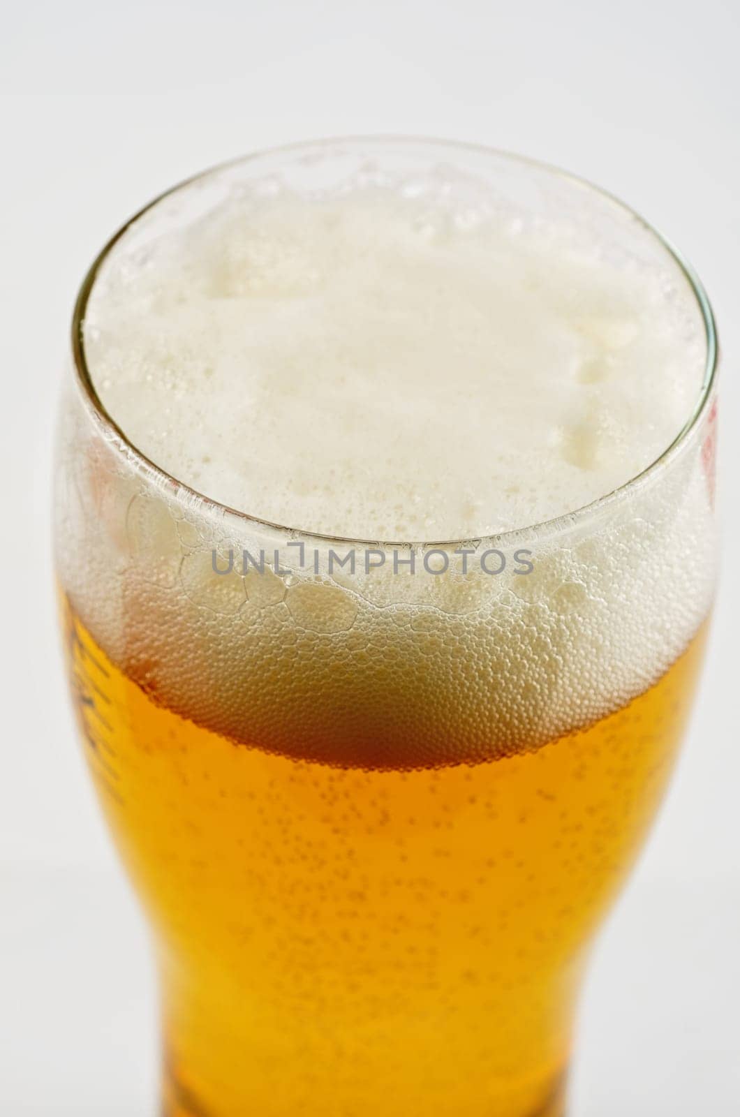 Glass of beer closeup on a white background
