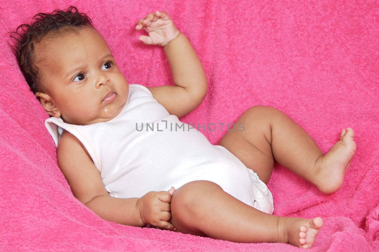 Adorable and beautiful baby on a pink towel