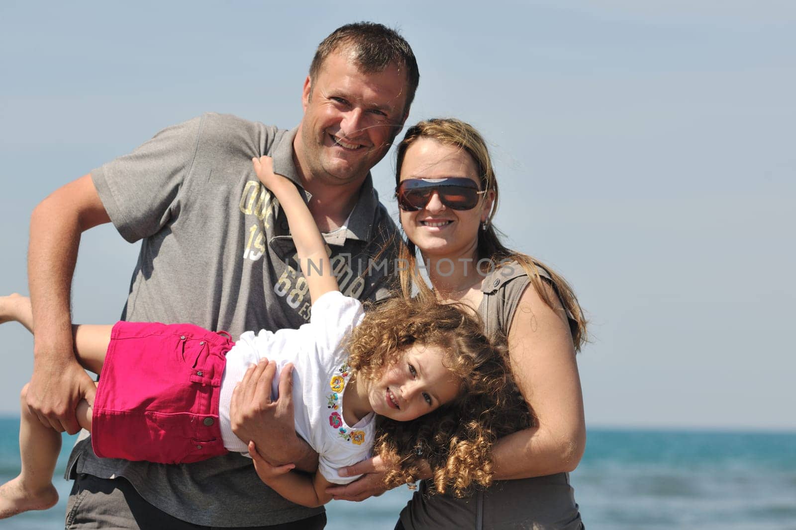 happy young family have fun and live healthy lifestyle on beach