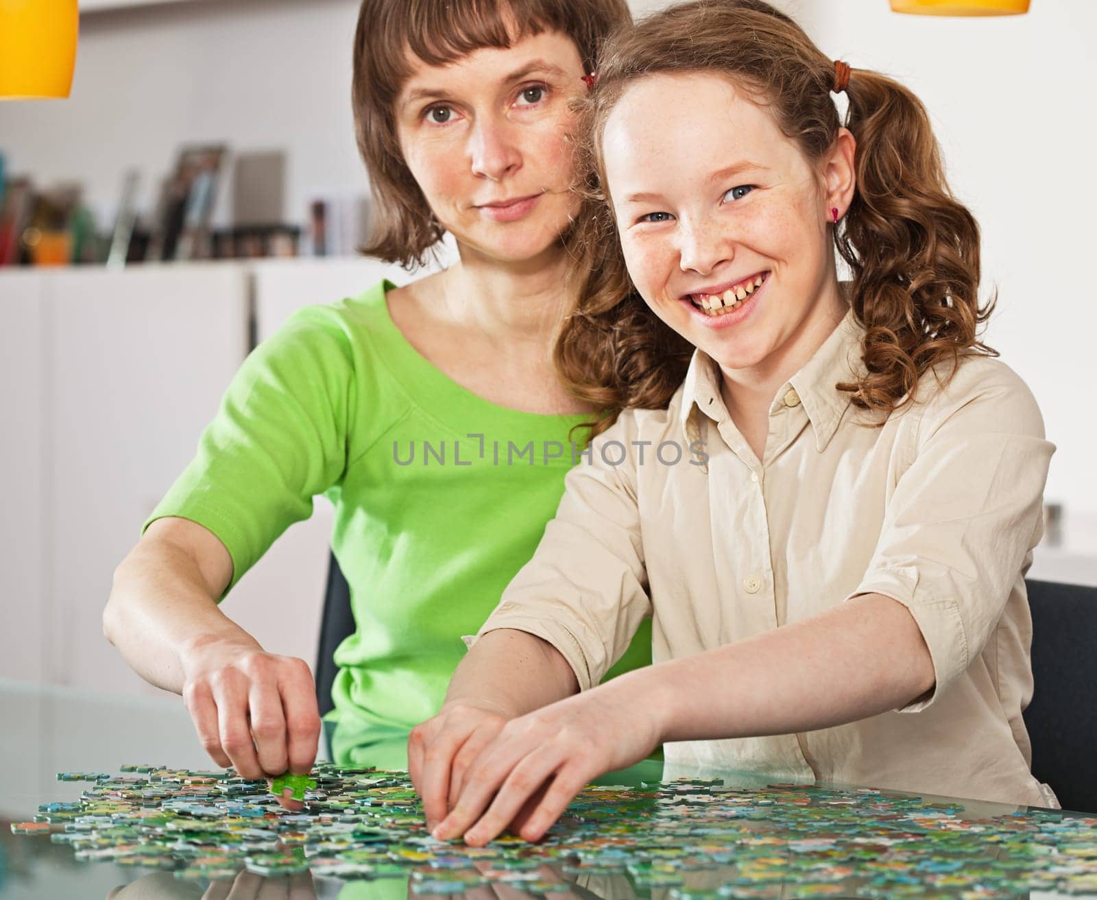Teenager girl and her mother doing a puzzle at home