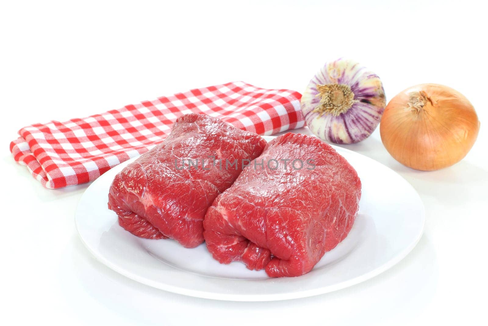Two raw beef roulades against white background