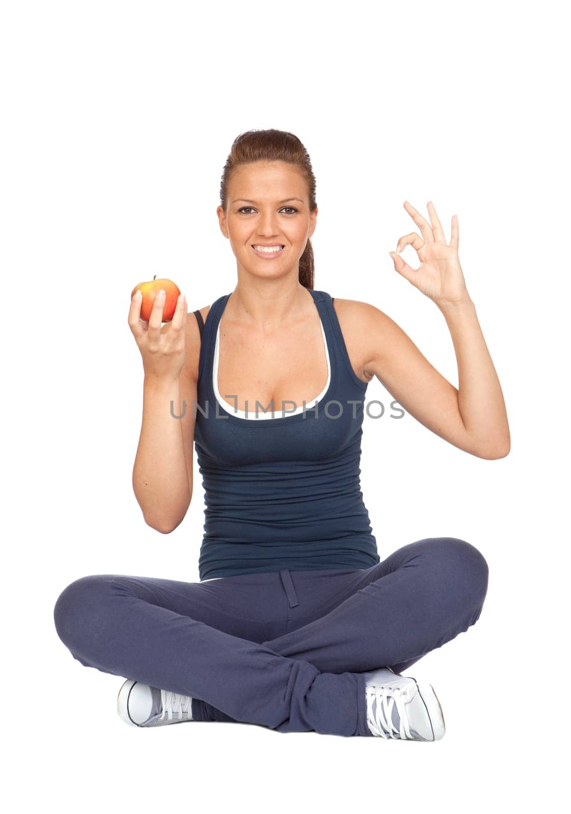 Gymnastics girl with an apple sitting with cross-legs on white background