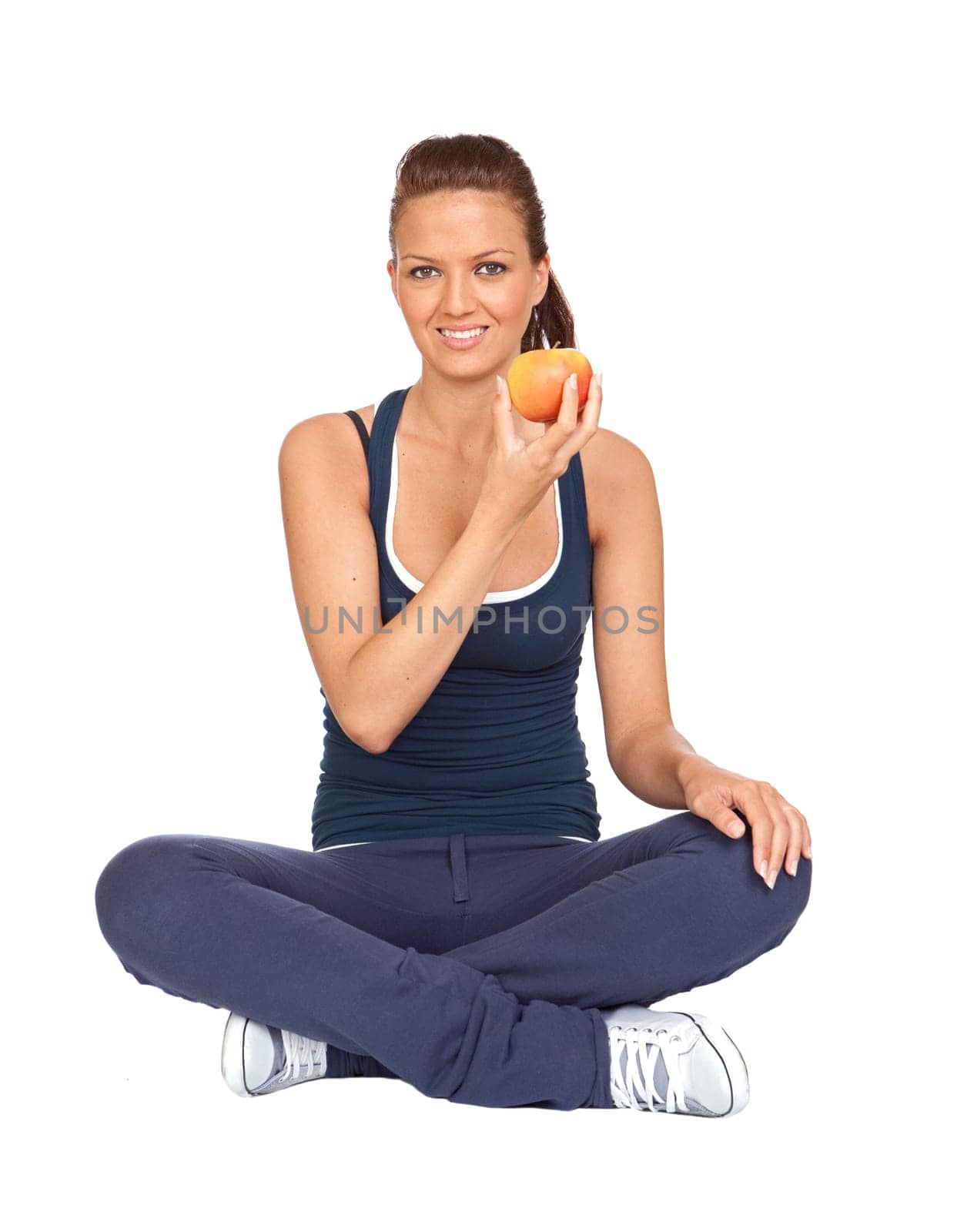 Gymnastics girl with an apple sitting with cross-legs on white background