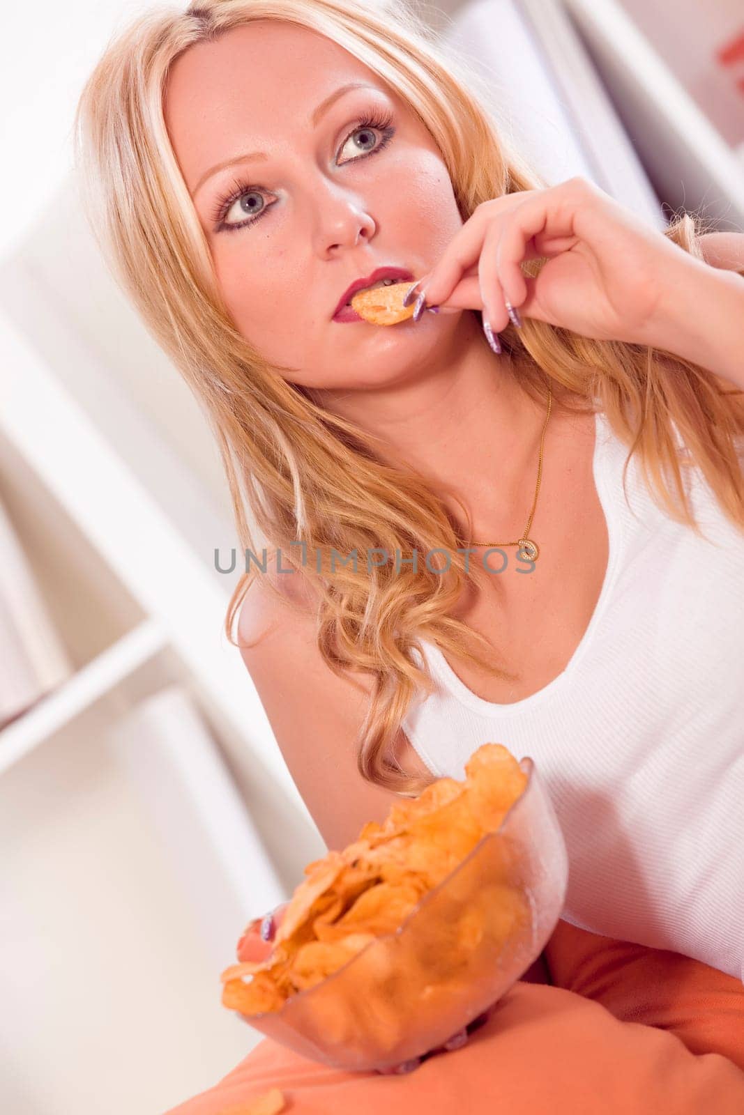 frustrated and unhappy woman eating chips