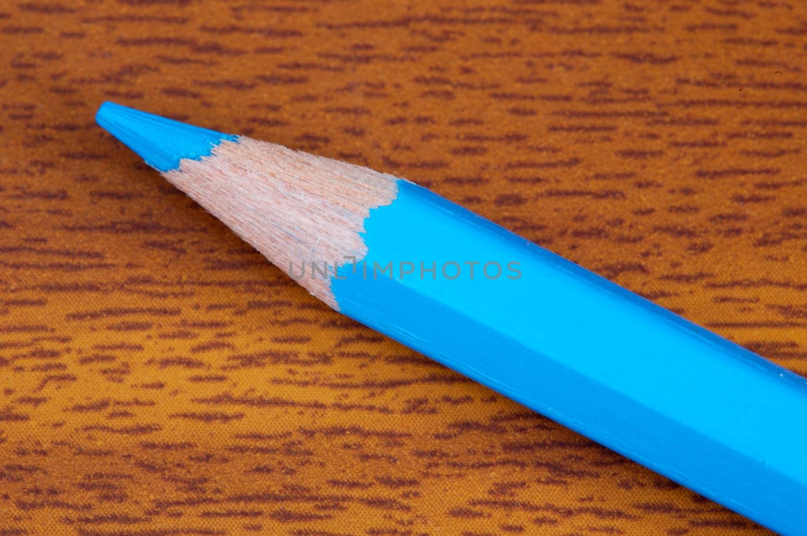 a photo of a blue pencil on the wood background