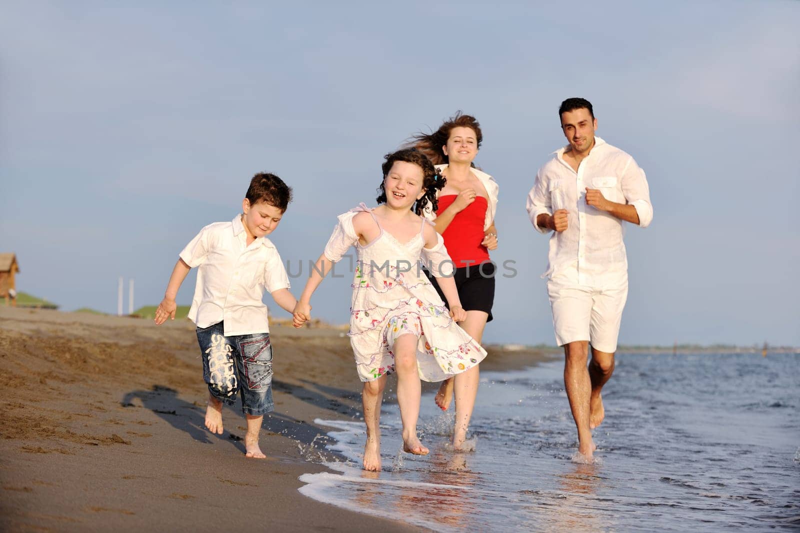 happy young family have fun and live healthy lifestyle on beach