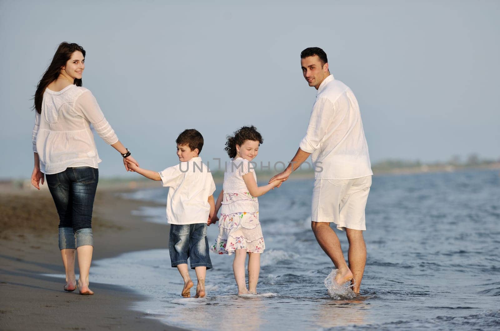 happy young family have fun and live healthy lifestyle on beach
