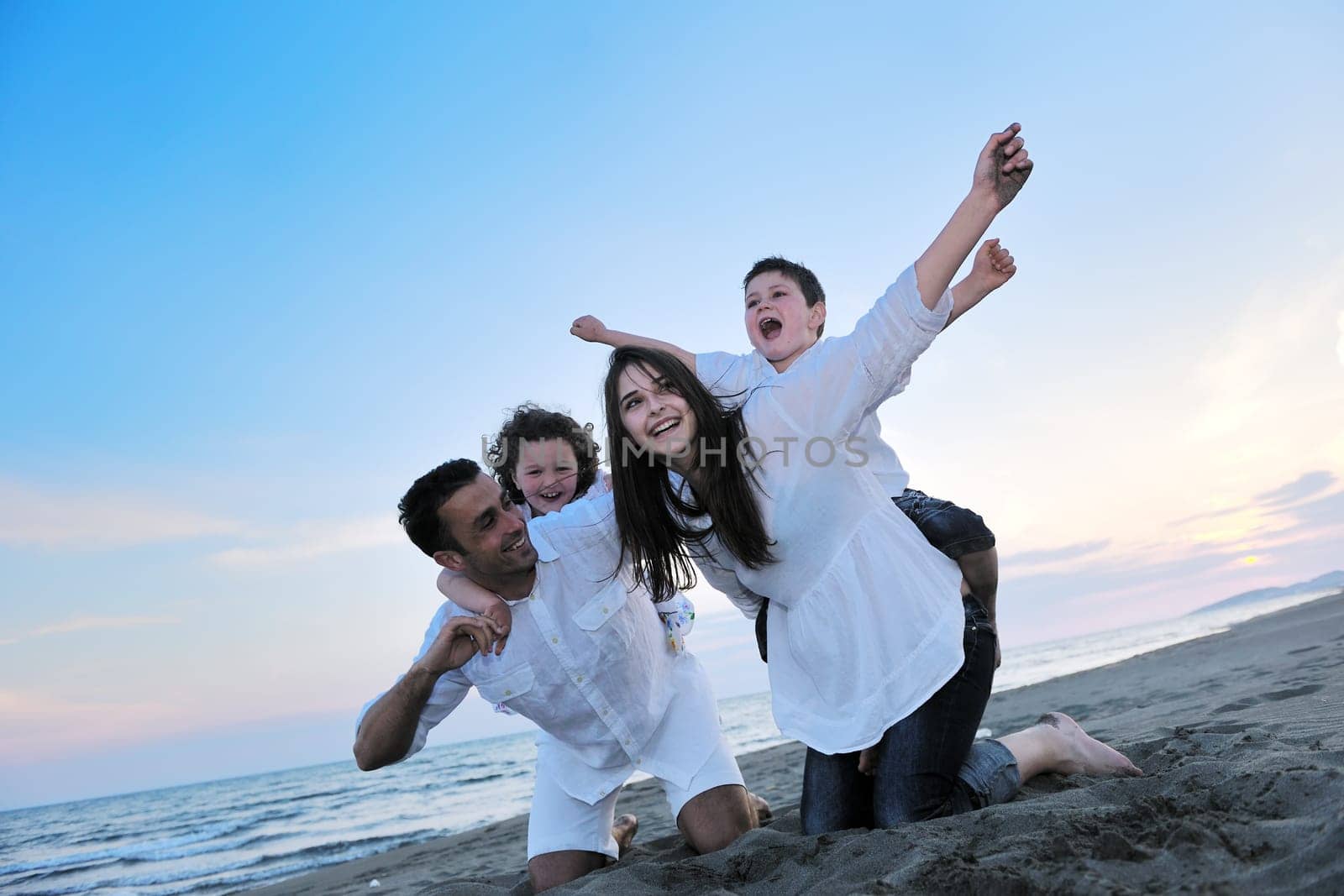 happy young family have fun and live healthy lifestyle on beach