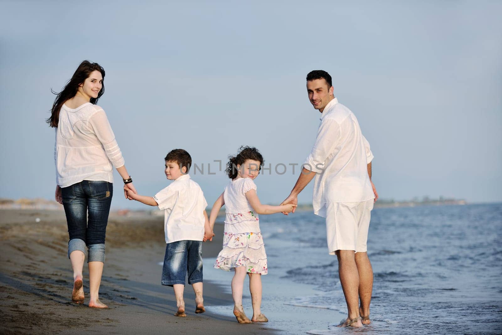 happy young family have fun and live healthy lifestyle on beach
