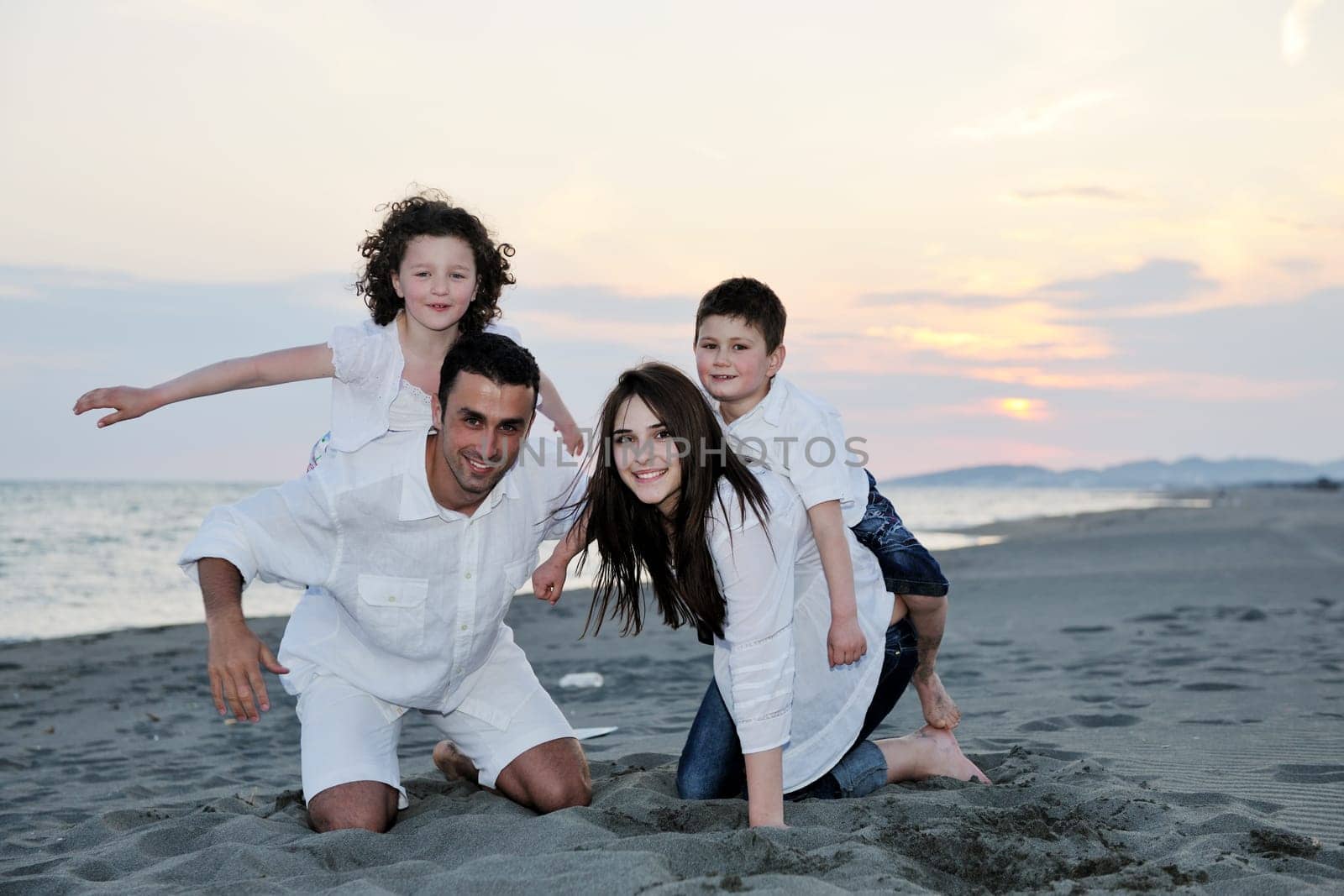 happy young family have fun and live healthy lifestyle on beach