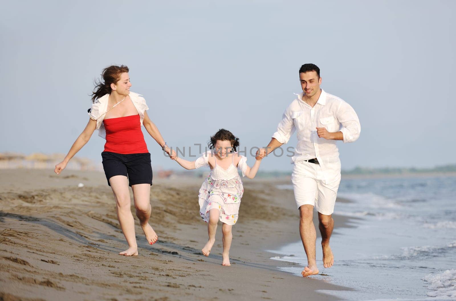 happy young family have fun and live healthy lifestyle on beach