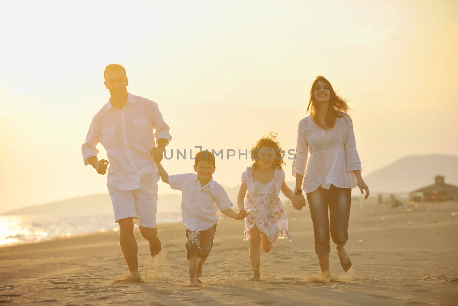 happy young family have fun and live healthy lifestyle on beach