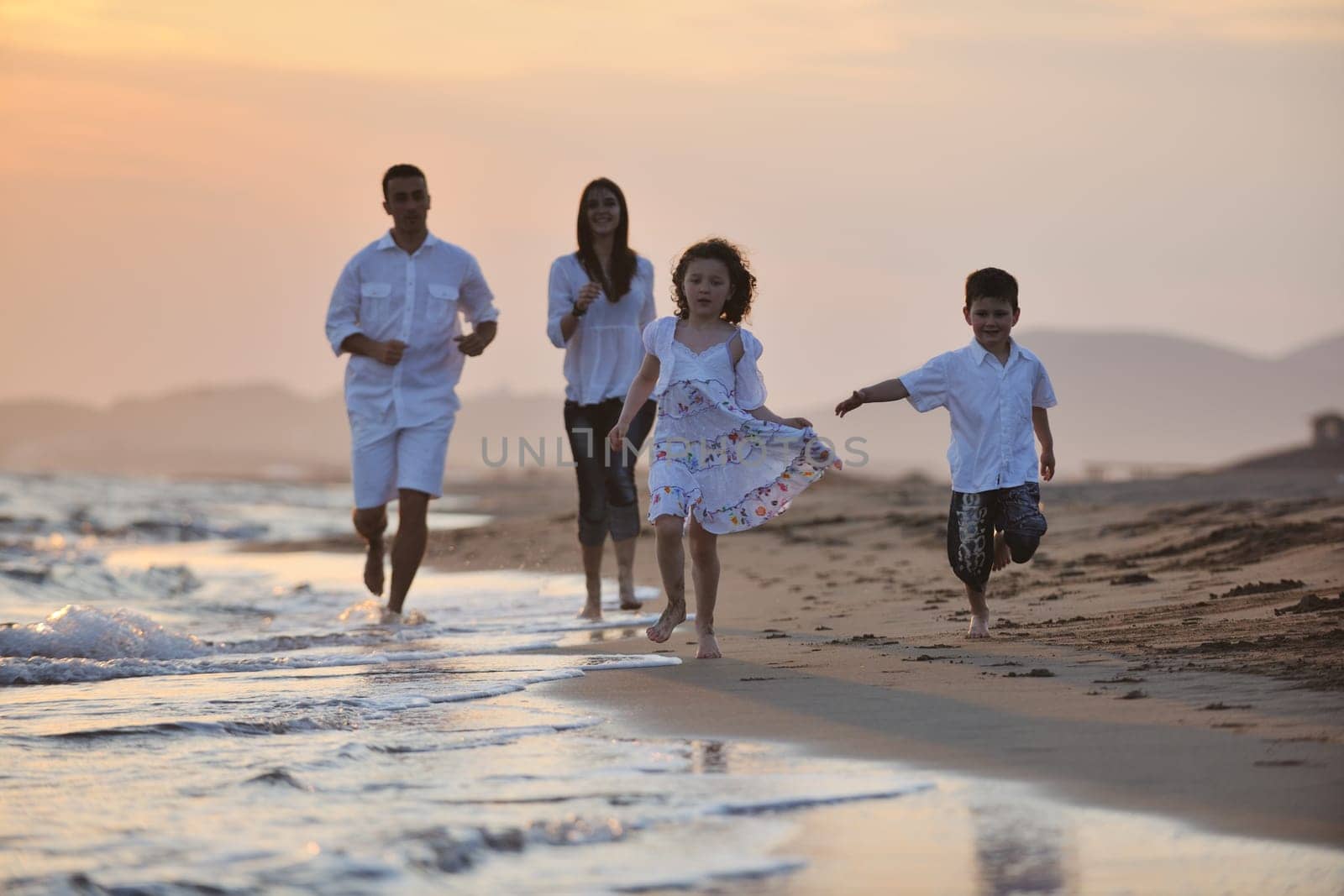happy young family have fun and live healthy lifestyle on beach