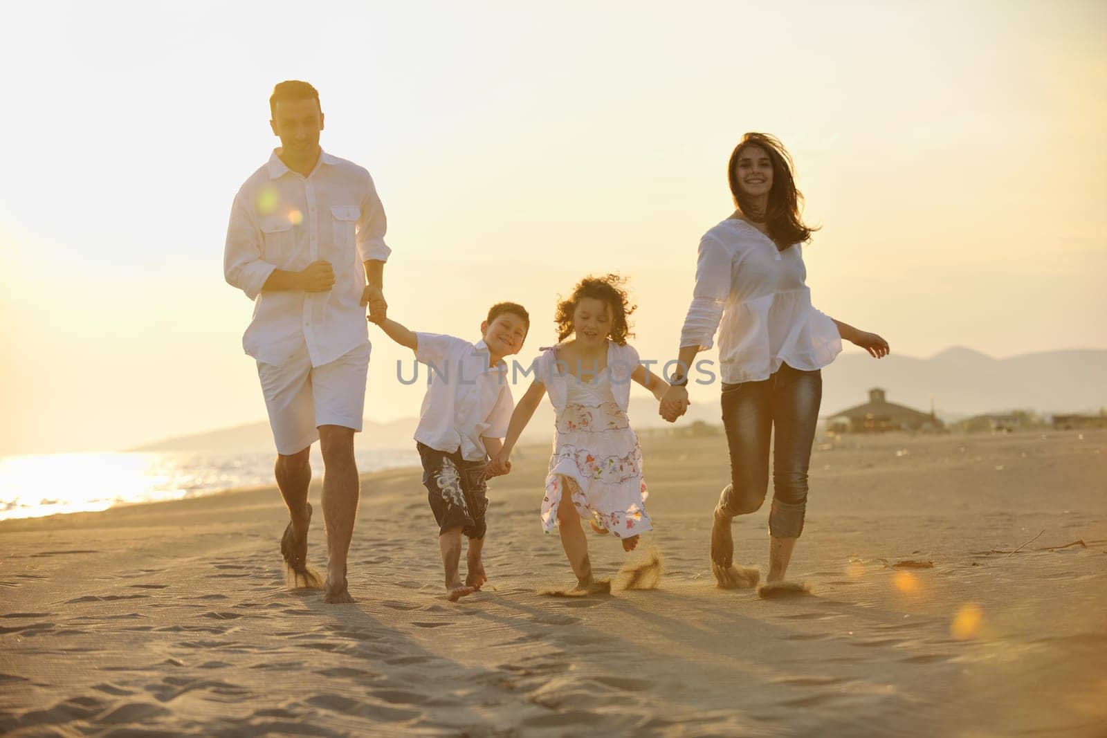 happy young family have fun and live healthy lifestyle on beach