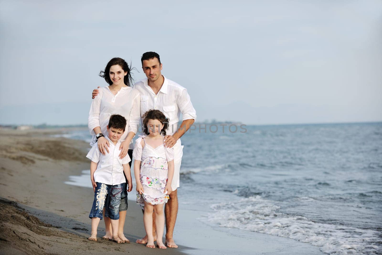 happy young family have fun and live healthy lifestyle on beach