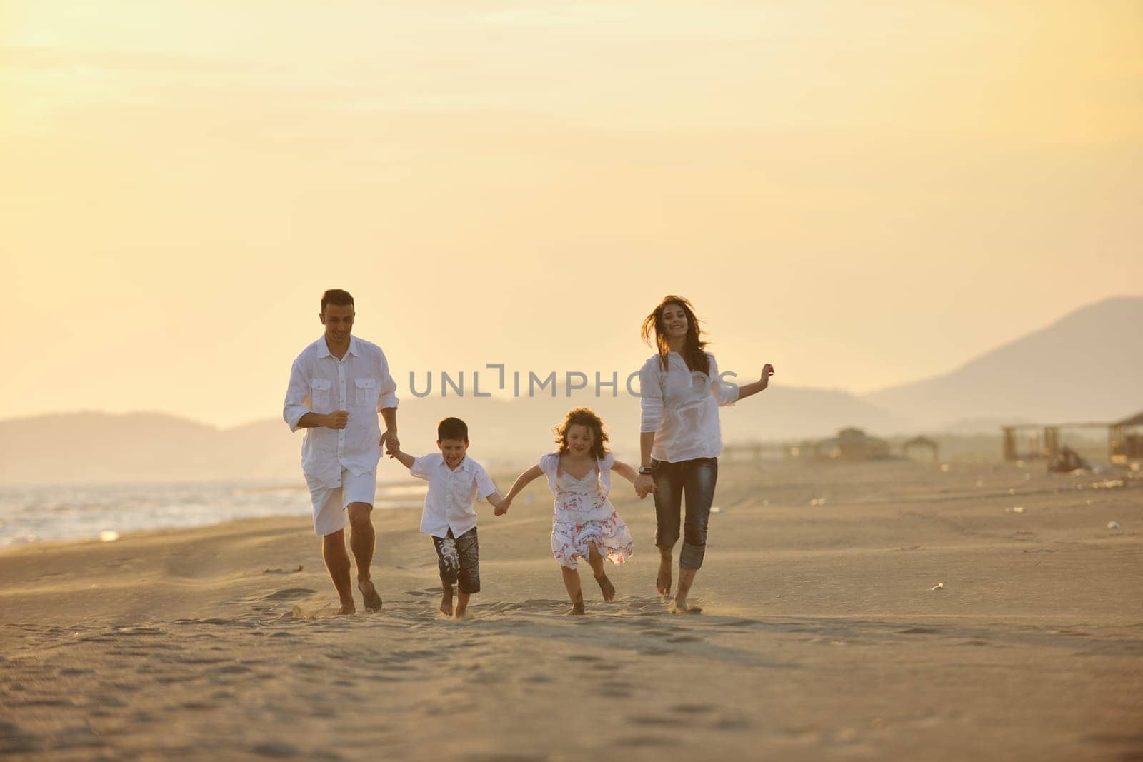 happy young family have fun and live healthy lifestyle on beach