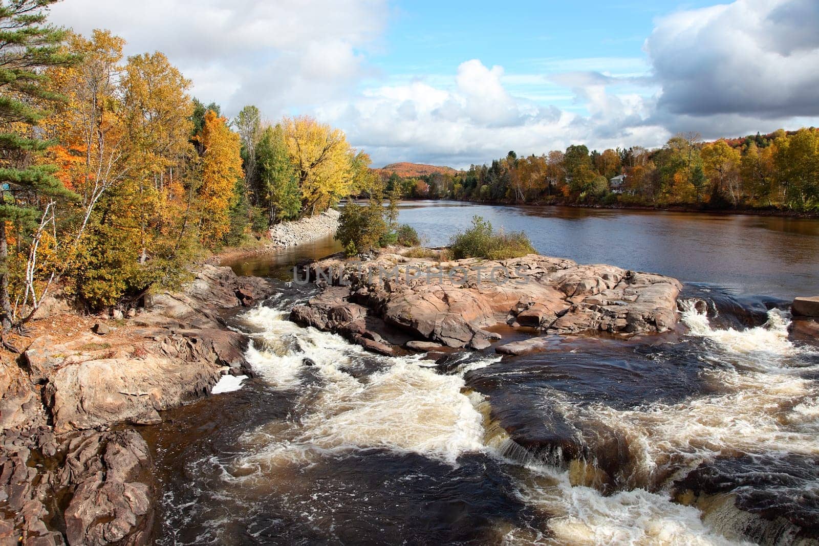 This is a beautiful view of a cascading river on a fall day.