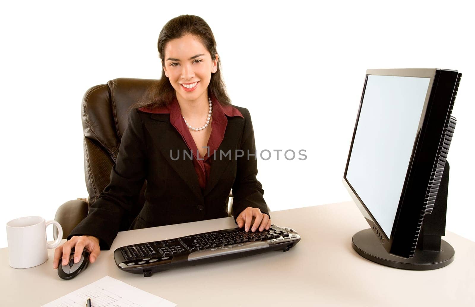 Beautiful businesswoman is sitting at her desk and smiling at the camera.