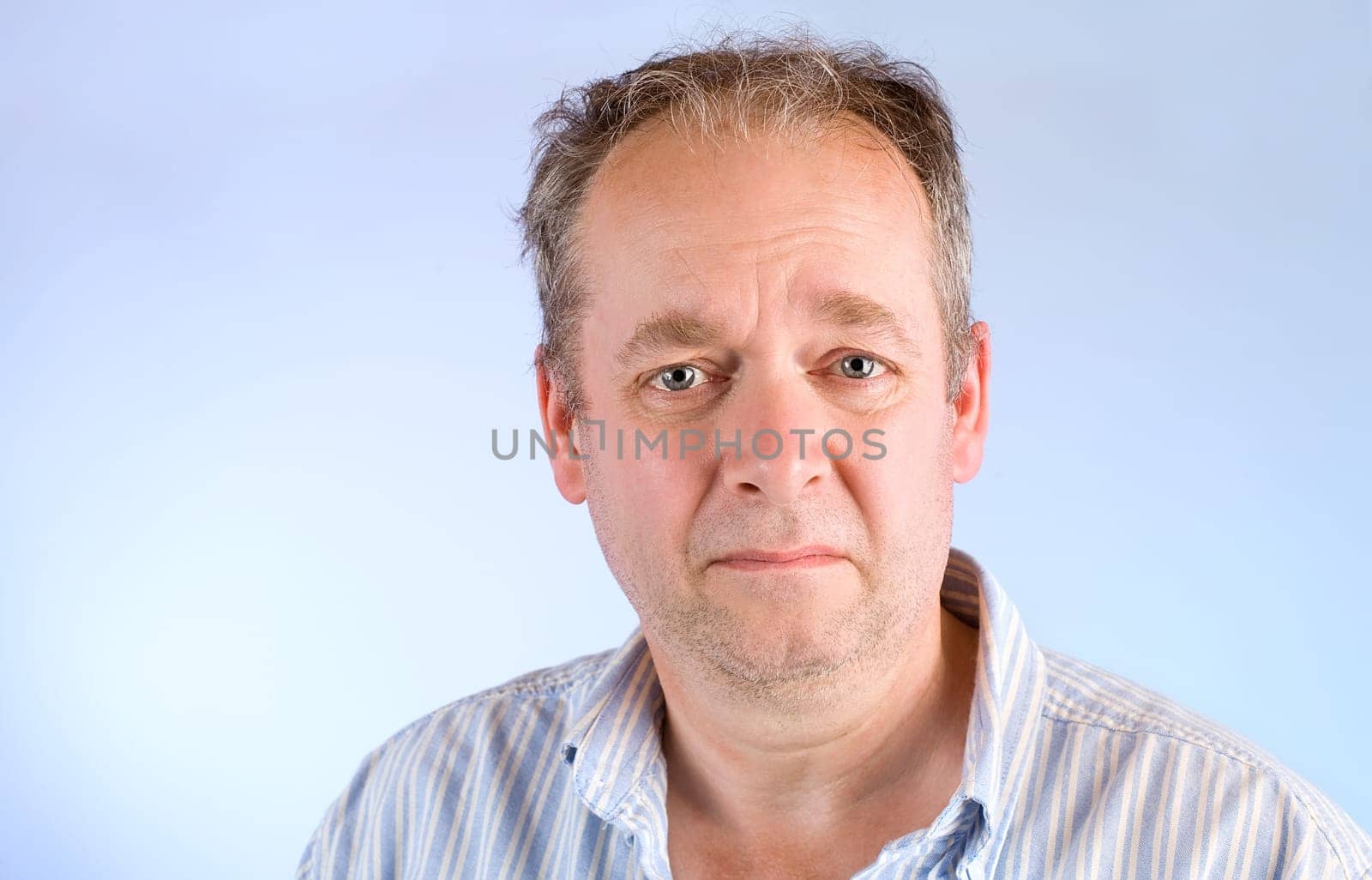 A middle-aged man is depressed or unhappy about something.