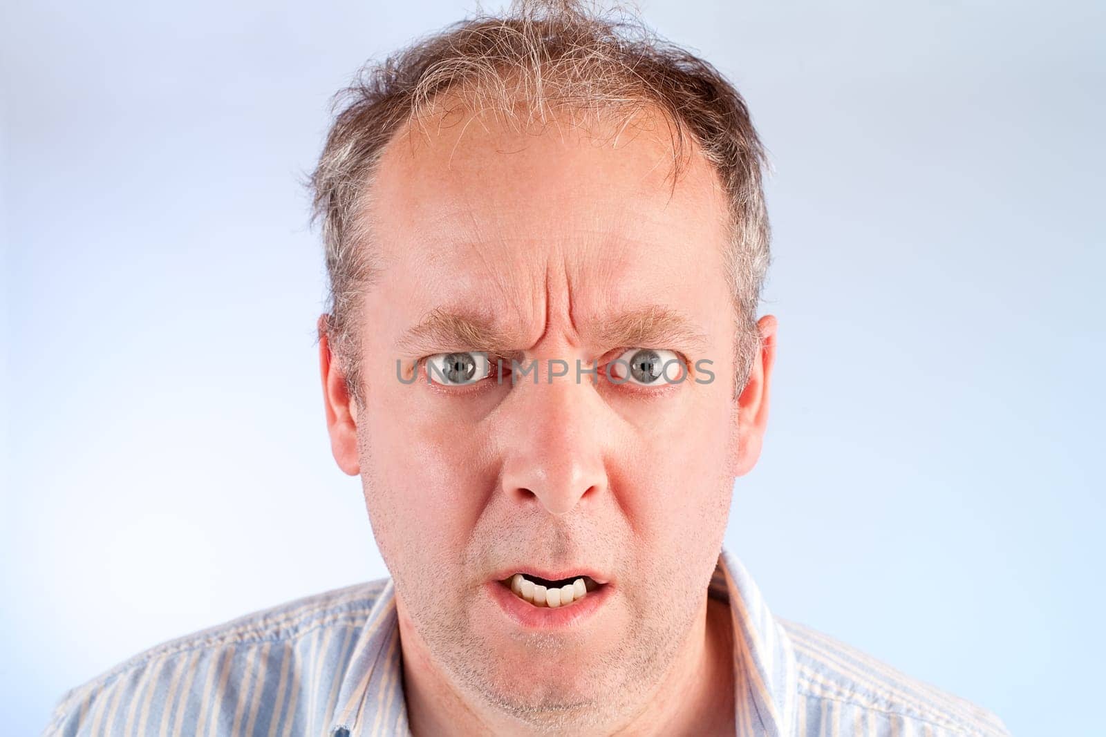 A man looking at the camera is angry about something.
