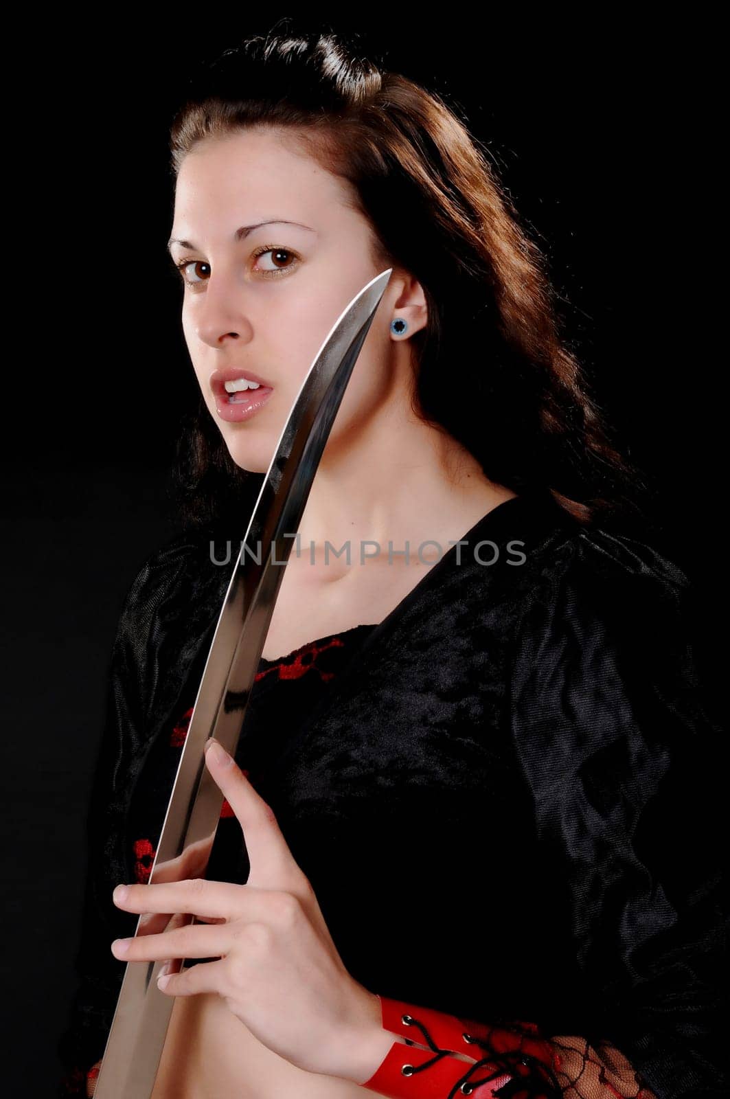 Portrait of a young and tough blond girl with a sword