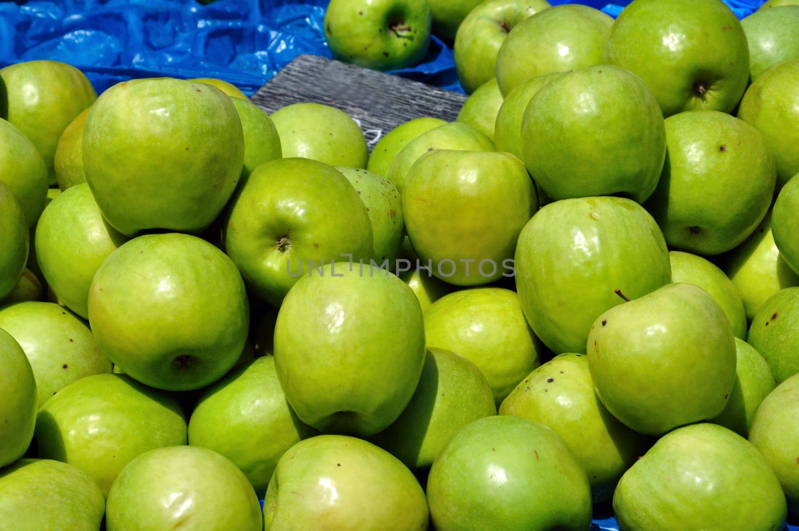 Green apples for sale at grocery store. Fruit background.