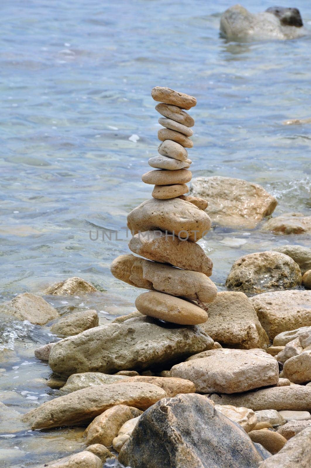 Primitive stone structure on rocky shore. Balanced rocks by the sea water.