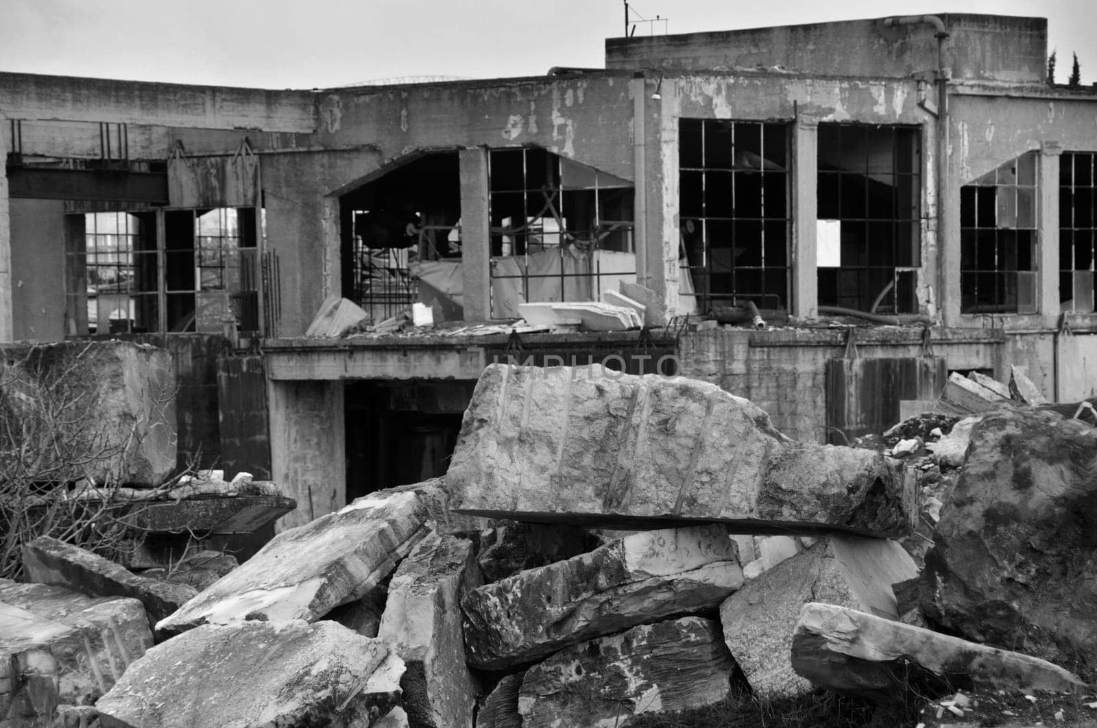 Abandoned marble processing factory and pile of granite slates. Black and white.