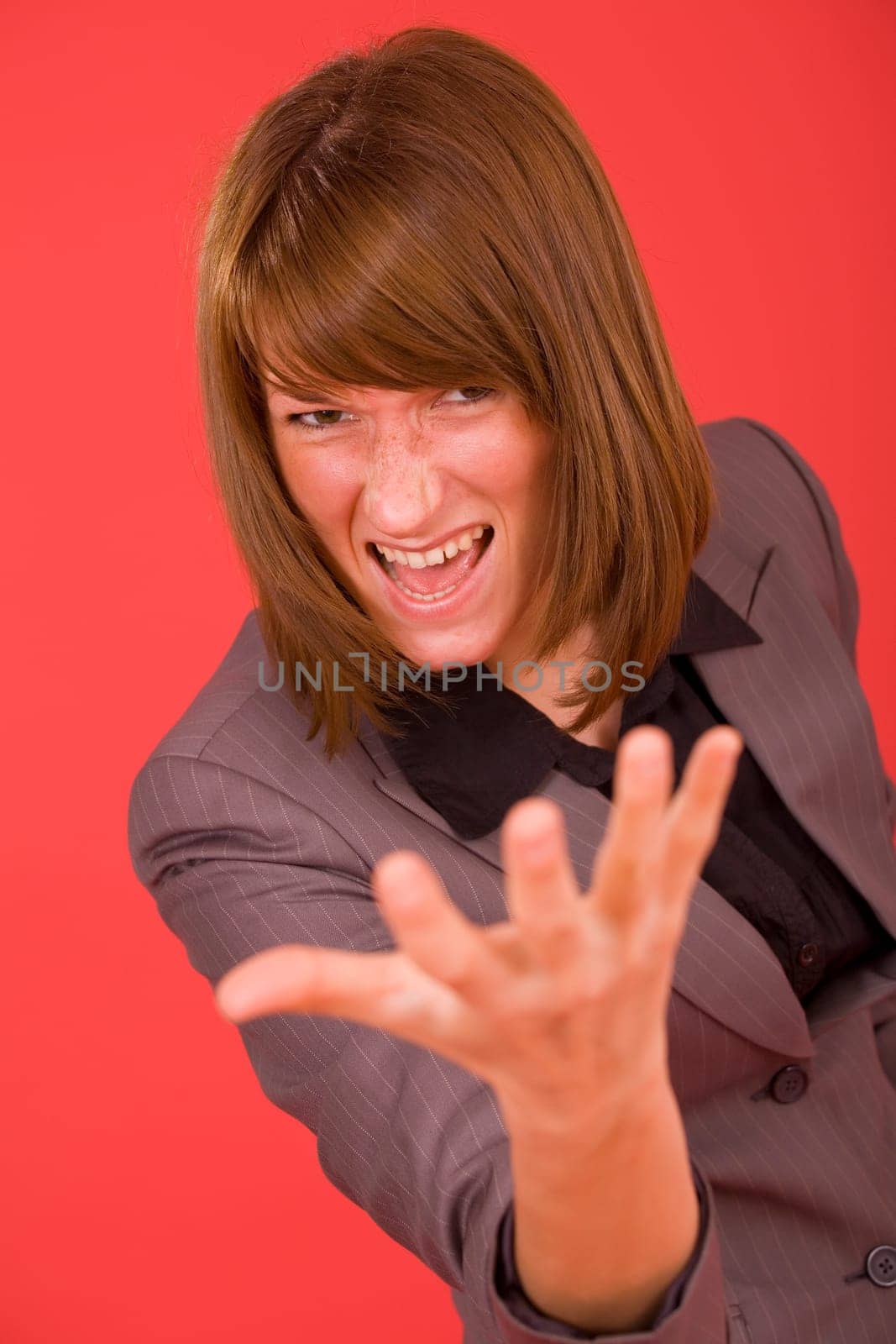 frustrated woman in grey suit over red background