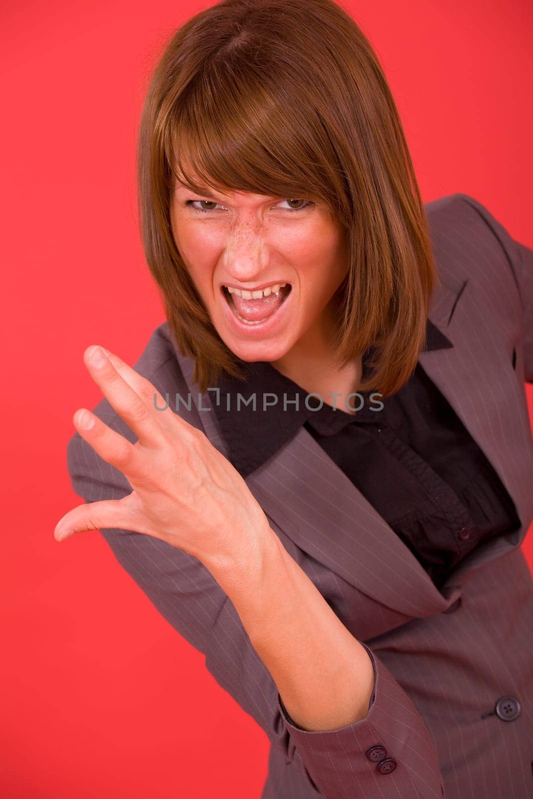 frustrated and screaming business woman over red background
