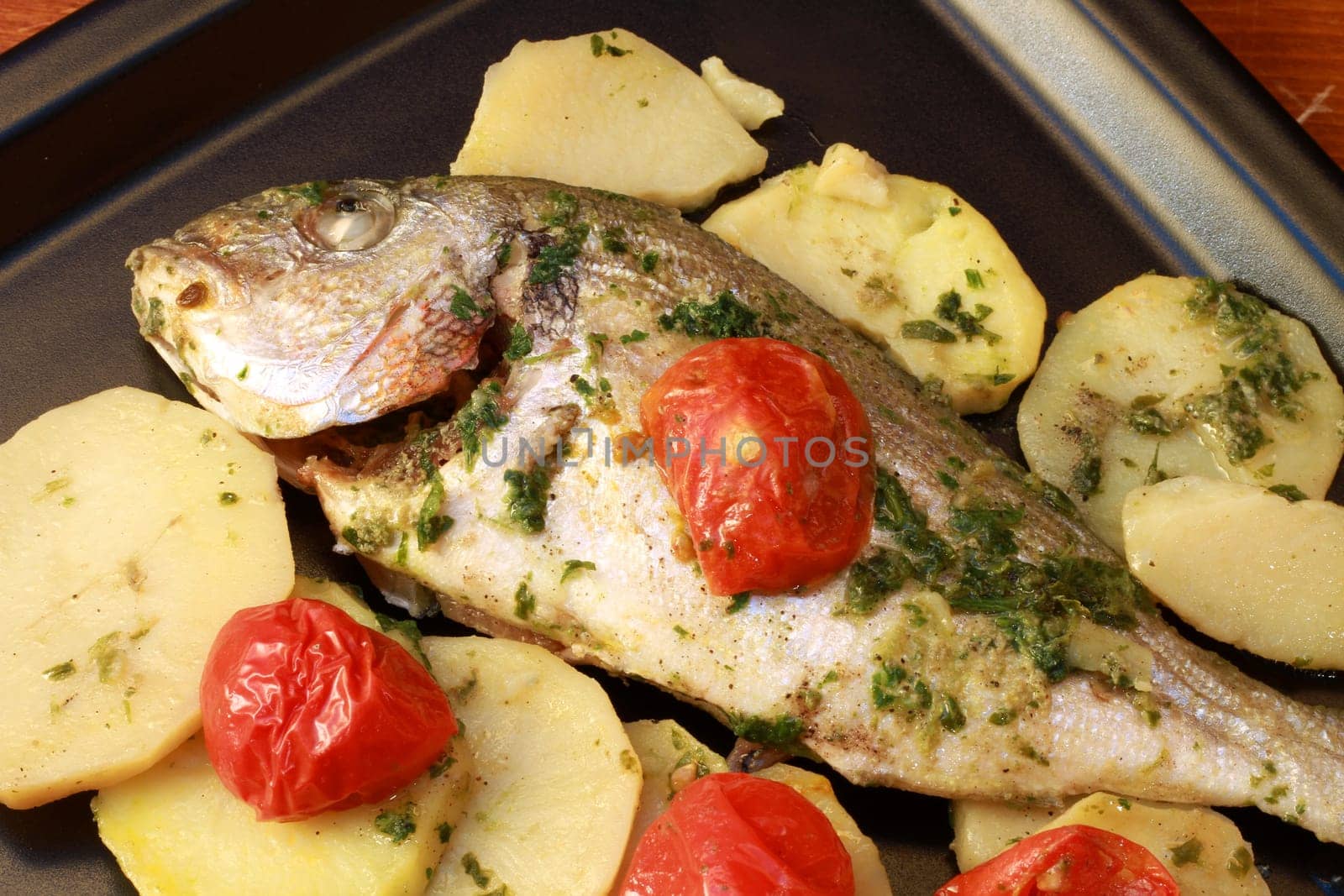 dish with gilthead with tomatoes and potatoes