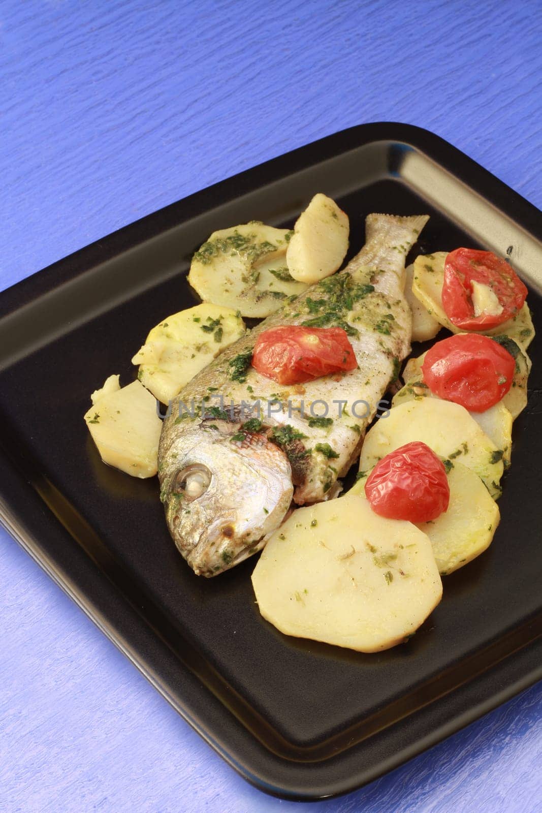 dish with gilthead with tomatoes and potatoes