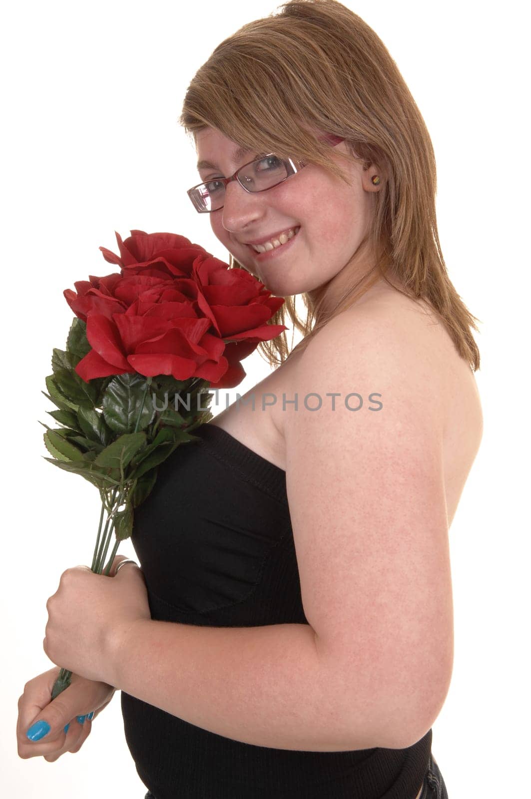 Smiling teenager holding a bunch of red roses to her chest, smiling into the  camera, in closeup and with glasses, for white background.