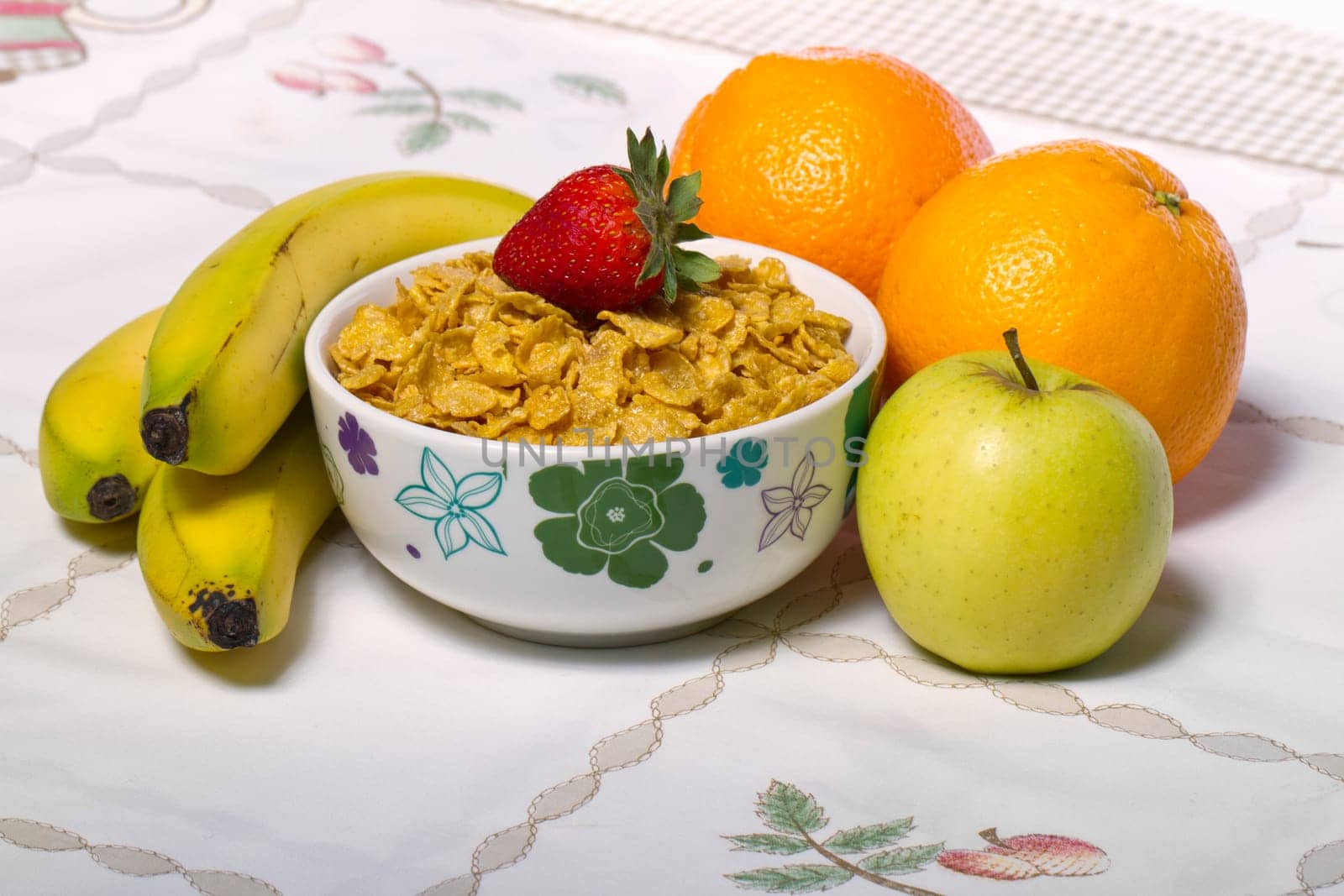 View of a bowl of cereals surrounded by fruit.