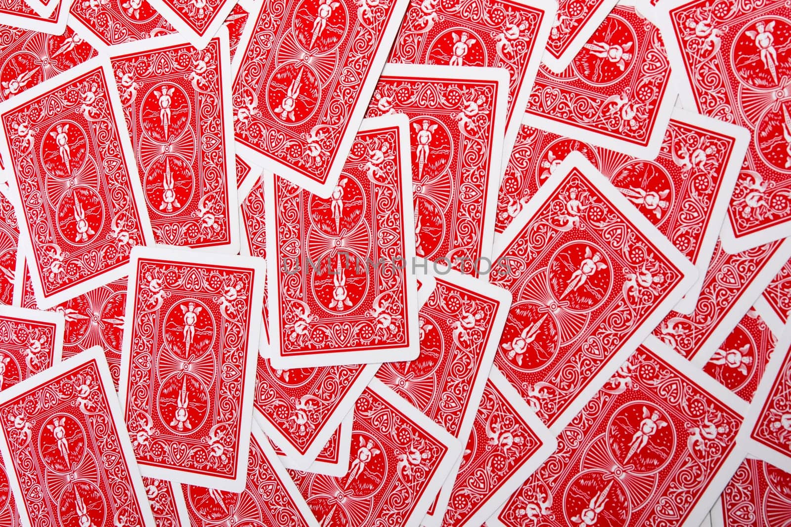 Close up view of a bunch of flipped playing cards spread on a green cloth table.